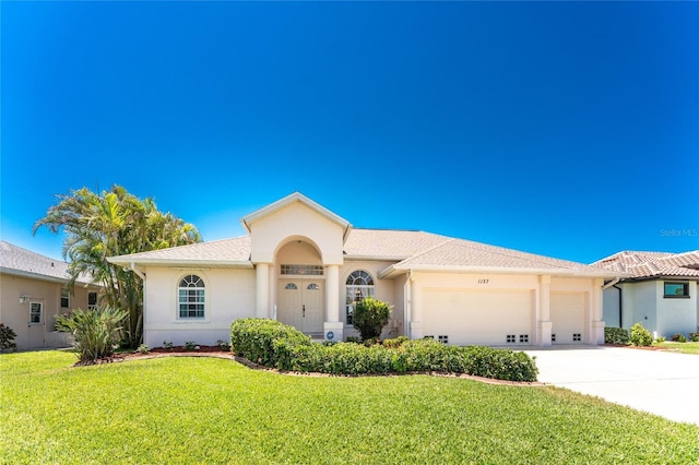 1157 Rotonda Cir, Rotonda West, FL 33947 - view of front of home featuring a garage, stucco siding, concrete driveway, and a front lawn