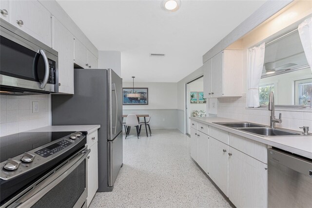 1691 Lakeview Pl, Englewood, FL 34223 - kitchen featuring appliances with stainless steel finishes, a sink, dark speckled floor, and tasteful backsplash