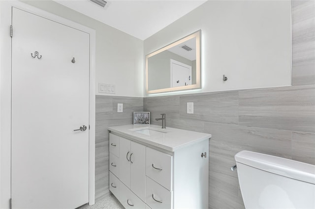 1691 Lakeview Pl, Englewood, FL 34223 - bathroom with tile walls, toilet, vanity, and wainscoting