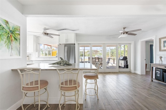 2060 Oyster Creek Dr, Englewood, FL 34224 - kitchen featuring freestanding refrigerator, ceiling fan, wood finished floors, and a kitchen bar