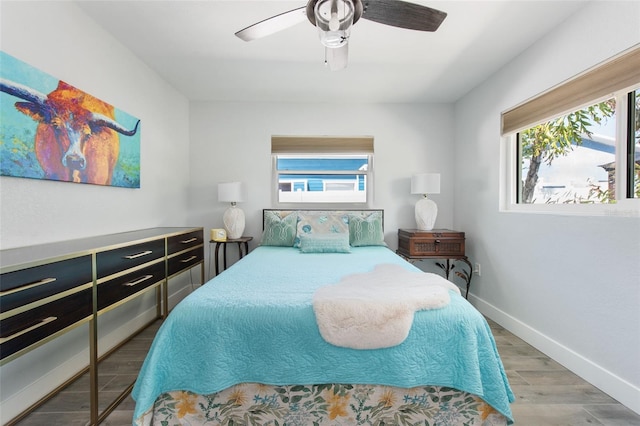 2060 Oyster Creek Dr, Englewood, FL 34224 - bedroom featuring multiple windows, wood finished floors, baseboards, and ceiling fan