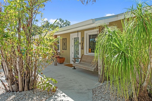 2060 Oyster Creek Dr, Englewood, FL 34224 - view of exterior entry with stucco siding and a porch