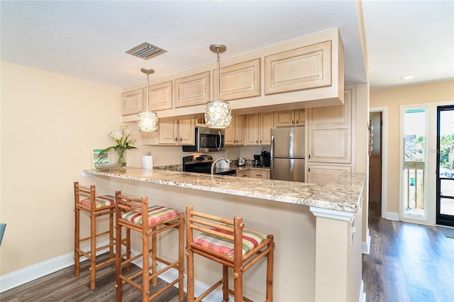 kitchen featuring appliances with stainless steel finishes, a peninsula, dark wood finished floors, baseboards, and light stone countertops