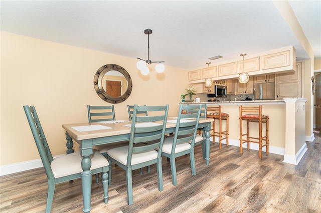 dining area with wood finished floors and baseboards