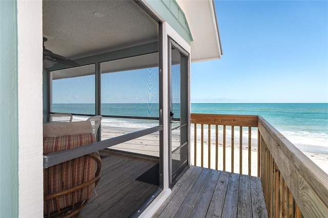 wooden terrace featuring view of water and beach
