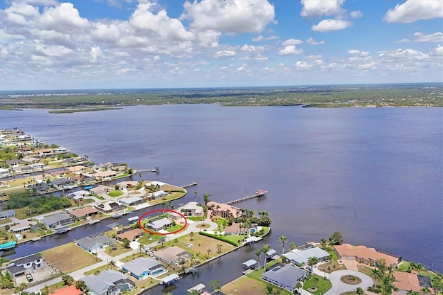 aerial view of property's location featuring a large body of water and nearby suburban area