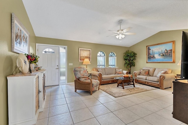 living area featuring lofted ceiling, a ceiling fan, light tile patterned flooring, and baseboards