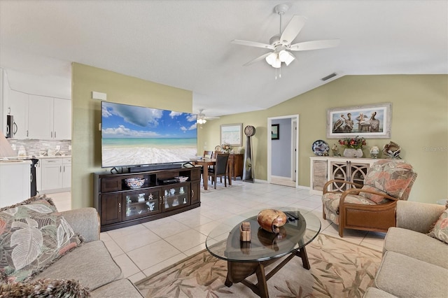 living area featuring a ceiling fan, light tile patterned floors, and lofted ceiling