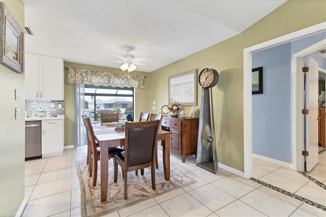 dining room featuring a ceiling fan, light tile patterned flooring, baseboards, and a textured ceiling