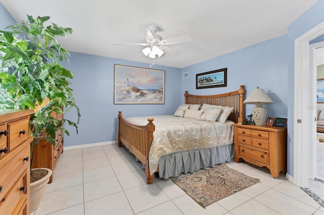 bedroom featuring a textured ceiling, light tile patterned floors, ceiling fan, and baseboards