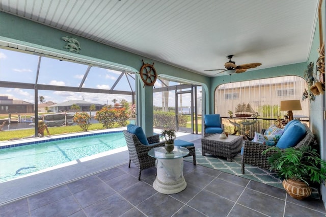 sunroom / solarium with ceiling fan and a swimming pool