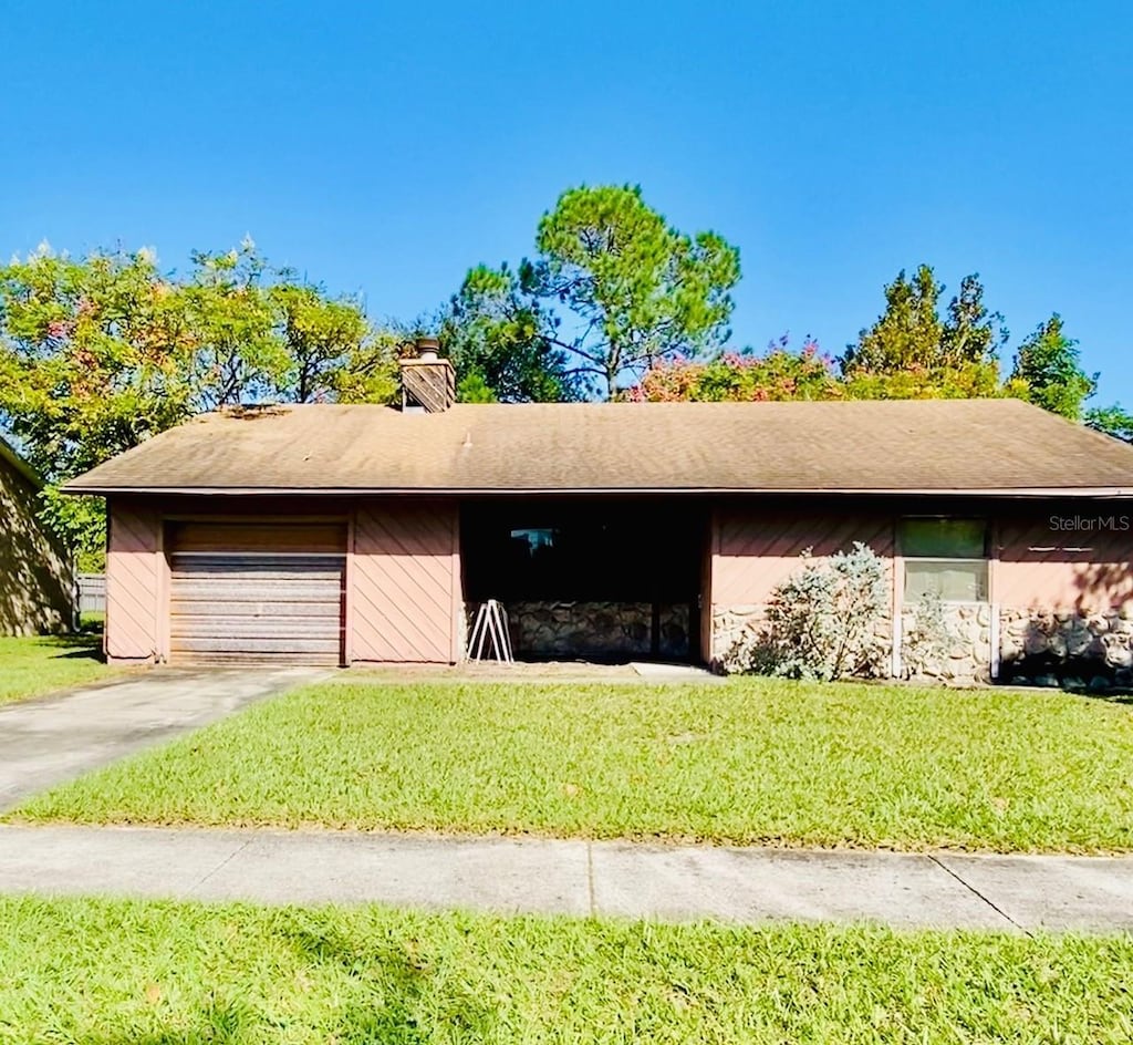 7639 Panthera Ct, Orlando, FL 32822 - view of front of property featuring concrete driveway, a garage, a front lawn, and a chimney