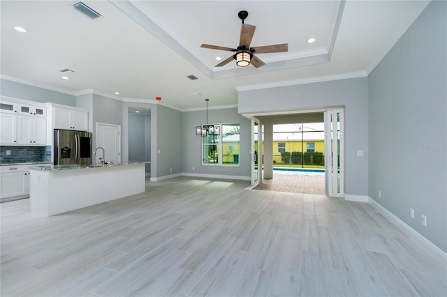 13344 Gershwin Ln, Port Charlotte, FL 33981 - unfurnished living room with ceiling fan, light wood-style flooring, a raised ceiling, baseboards, and recessed lighting