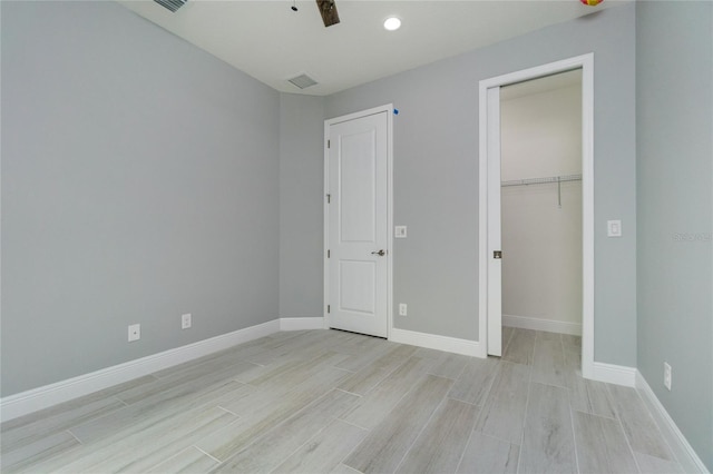 13344 Gershwin Ln, Port Charlotte, FL 33981 - unfurnished bedroom with light wood finished floors, baseboards, a closet, and a walk in closet