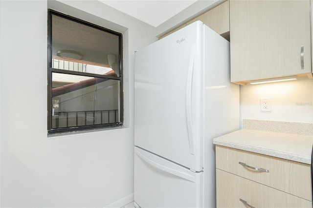 1551 Beach Rd Unit 212, Englewood, FL 34223 - kitchen featuring freestanding refrigerator, light brown cabinetry, and light countertops