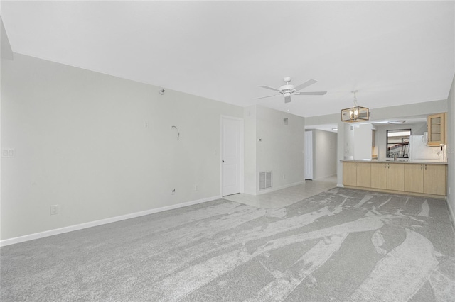 1551 Beach Rd Unit 212, Englewood, FL 34223 - unfurnished living room featuring light carpet, a ceiling fan, baseboards, and a chandelier
