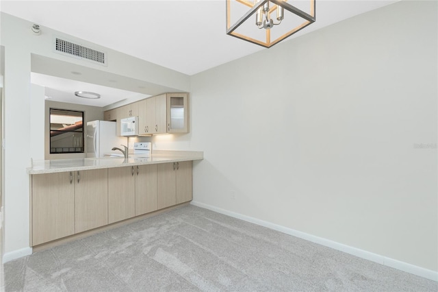 1551 Beach Rd Unit 212, Englewood, FL 34223 - kitchen with white appliances, baseboards, light carpet, and a chandelier