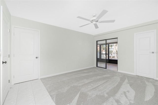 1551 Beach Rd Unit 212, Englewood, FL 34223 - unfurnished bedroom featuring baseboards, light carpet, light tile patterned flooring, and a ceiling fan