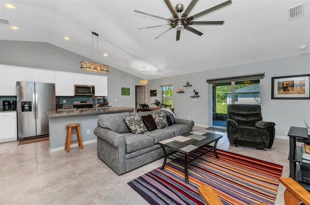 2678 Alva St, North Port, FL 34291 - living room with vaulted ceiling, light tile patterned floors, ceiling fan, and recessed lighting
