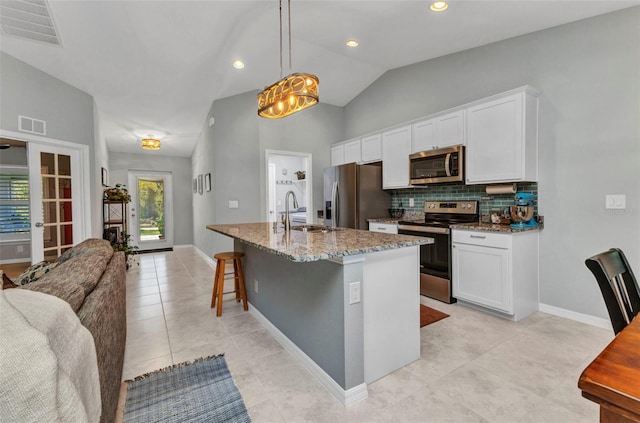 2678 Alva St, North Port, FL 34291 - kitchen with appliances with stainless steel finishes, a sink, light stone counters, white cabinets, and decorative backsplash