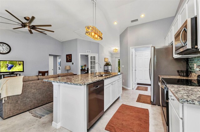 2678 Alva St, North Port, FL 34291 - kitchen featuring appliances with stainless steel finishes, white cabinets, a sink, open floor plan, and high vaulted ceiling