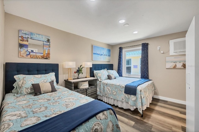 115 Friendship Ln, Englewood, FL 34223 - bedroom with wood finished floors, baseboards, a wall unit AC, and recessed lighting