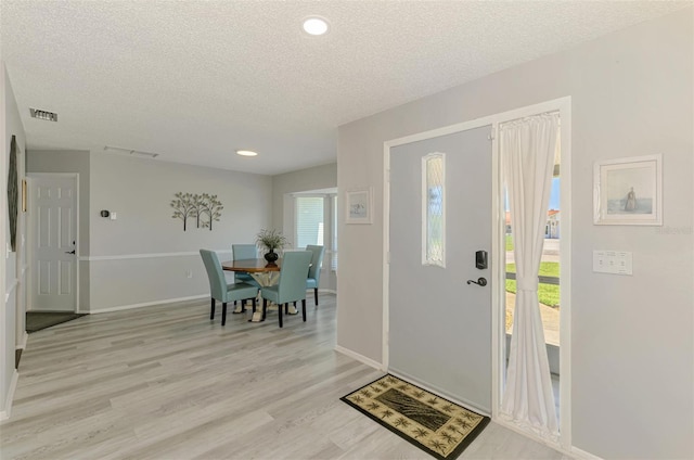 9869 Gulfstream Blvd, Englewood, FL 34224 - entryway featuring a textured ceiling, light wood finished floors, baseboards, and recessed lighting