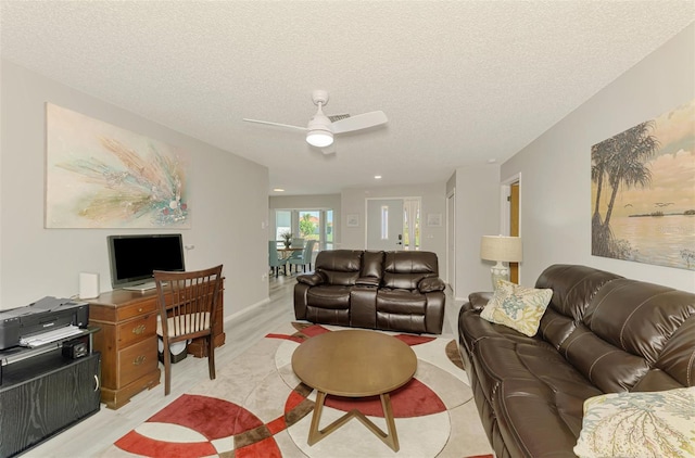9869 Gulfstream Blvd, Englewood, FL 34224 - living room featuring a ceiling fan, a textured ceiling, and light wood finished floors