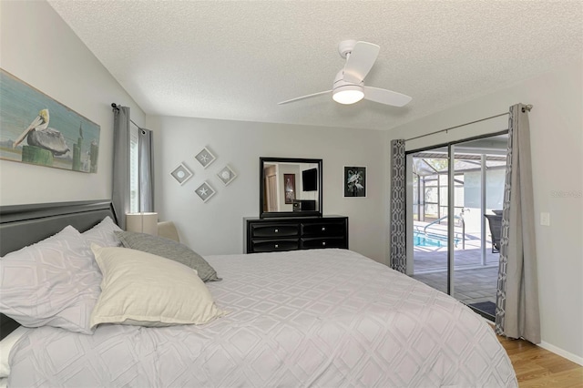 9869 Gulfstream Blvd, Englewood, FL 34224 - bedroom featuring access to exterior, light wood-style flooring, a textured ceiling, and a ceiling fan