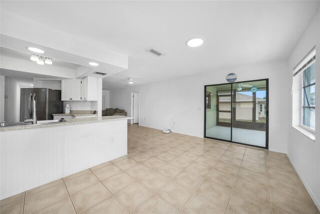 279 Mark Twain Ln, Rotonda West, FL 33947 - kitchen featuring freestanding refrigerator, white cabinetry, ceiling fan, and open floor plan