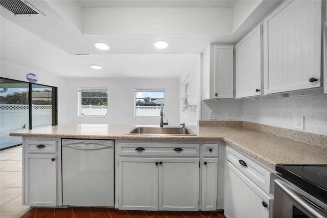 279 Mark Twain Ln, Rotonda West, FL 33947 - kitchen featuring dishwasher, a sink, a peninsula, recessed lighting, and white cabinets