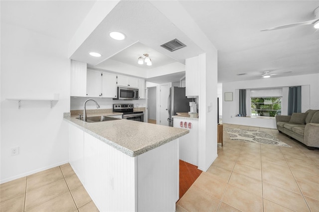 279 Mark Twain Ln, Rotonda West, FL 33947 - kitchen with stainless steel appliances, a sink, a ceiling fan, a peninsula, and light countertops