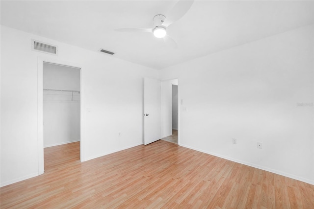 279 Mark Twain Ln, Rotonda West, FL 33947 - unfurnished bedroom with light wood-style flooring, a closet, a walk in closet, and baseboards