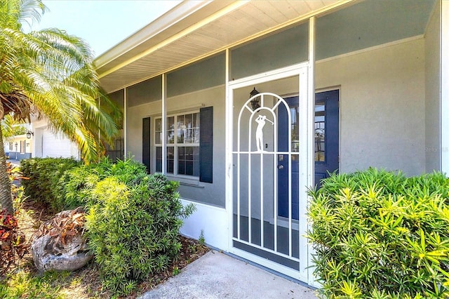 305 E Wentworth Cir, Englewood, FL 34223 - doorway to property featuring stucco siding and covered porch
