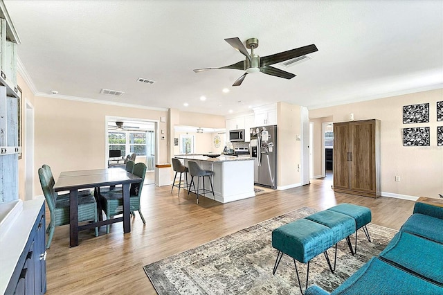 305 E Wentworth Cir, Englewood, FL 34223 - living area featuring a ceiling fan, crown molding, light wood-style floors, baseboards, and recessed lighting