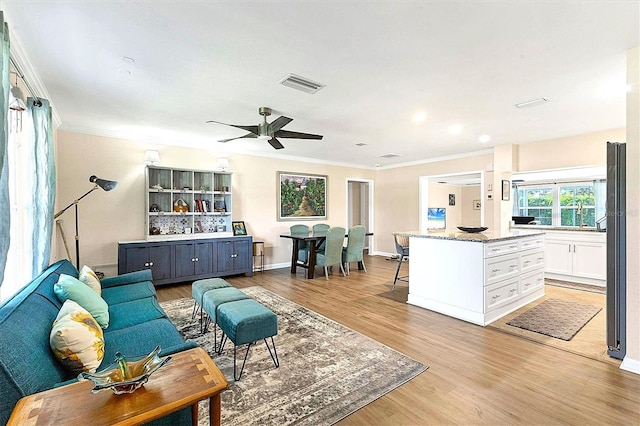 305 E Wentworth Cir, Englewood, FL 34223 - living room featuring crown molding, light wood finished floors, ceiling fan, and baseboards