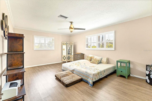 305 E Wentworth Cir, Englewood, FL 34223 - bedroom featuring wood finished floors, ornamental molding, a textured ceiling, baseboards, and ceiling fan