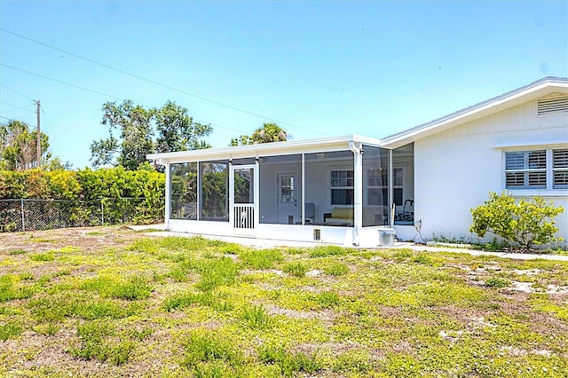 305 E Wentworth Cir, Englewood, FL 34223 - rear view of house featuring a sunroom and stucco siding