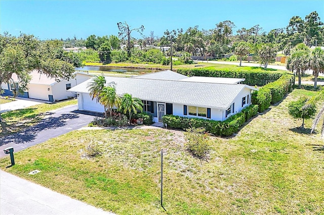 305 E Wentworth Cir, Englewood, FL 34223 - ranch-style home featuring driveway, a water view, an attached garage, and a front yard