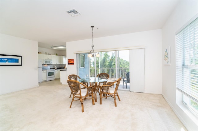 3929 Cape Haze Dr Unit 101, Rotonda West, FL 33947 - dining area with light colored carpet and a chandelier