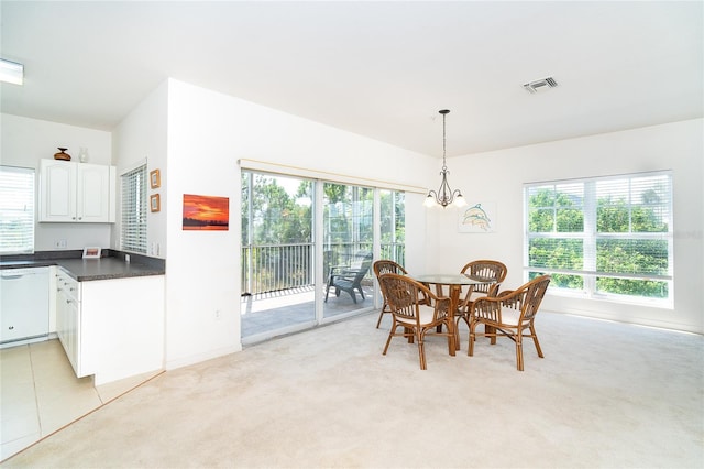 3929 Cape Haze Dr Unit 101, Rotonda West, FL 33947 - dining room with light colored carpet, a chandelier, and baseboards
