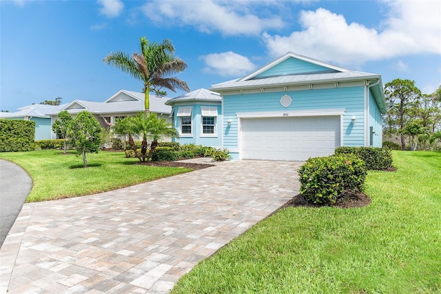 8952 Scallop Way, Placida, FL 33946 - ranch-style house with decorative driveway, a garage, a front yard, and metal roof