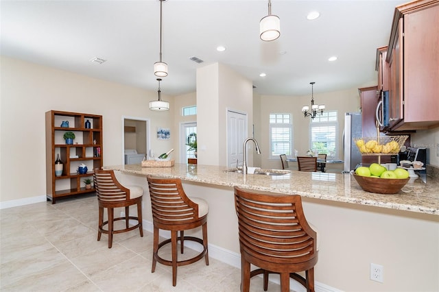 8952 Scallop Way, Placida, FL 33946 - kitchen with a sink, appliances with stainless steel finishes, a peninsula, light stone counters, and hanging light fixtures
