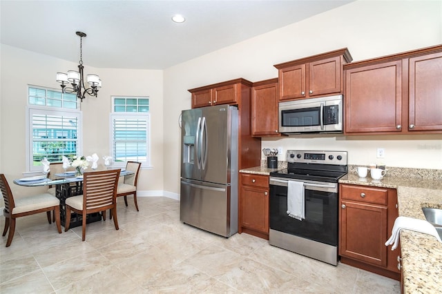8952 Scallop Way, Placida, FL 33946 - kitchen with stainless steel appliances, a chandelier, light stone countertops, brown cabinetry, and recessed lighting