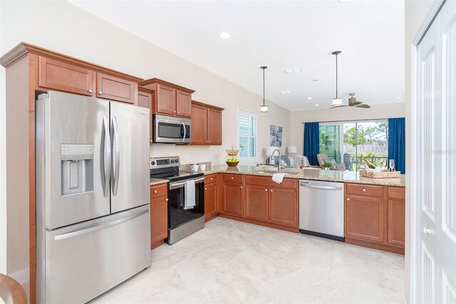 8952 Scallop Way, Placida, FL 33946 - kitchen with appliances with stainless steel finishes, a sink, brown cabinetry, light stone counters, and hanging light fixtures