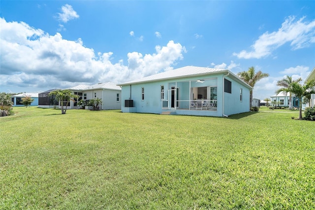 8952 Scallop Way, Placida, FL 33946 - rear view of house featuring a yard, a ceiling fan, metal roof, a sunroom, and stucco siding