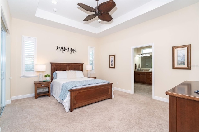 8952 Scallop Way, Placida, FL 33946 - bedroom with light colored carpet, a tray ceiling, baseboards, ensuite bath, and ceiling fan