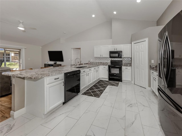 3695 Waffle Ter, North Port, FL 34286 - kitchen with black appliances, a peninsula, a sink, open floor plan, and white cabinets