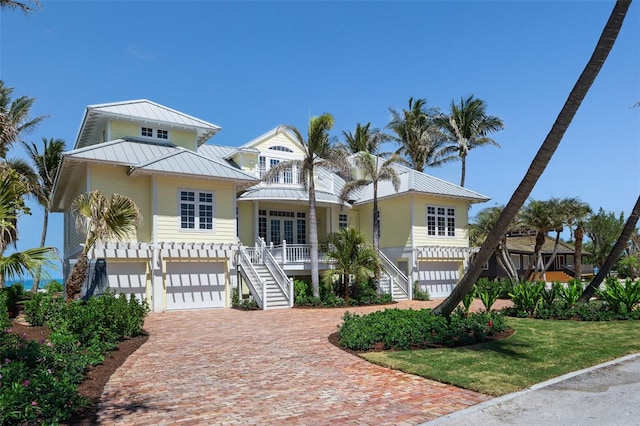 2979 Shore Ln, Boca Grande, FL 33921 - beach home featuring stairway, a standing seam roof, a garage, decorative driveway, and metal roof
