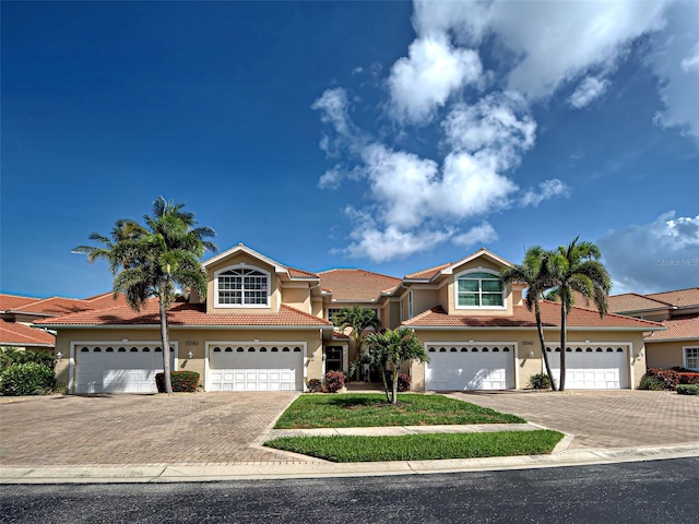 2590 Tarpon Cove Dr Unit 811, Punta Gorda, FL 33950 - view of front of house with stucco siding, decorative driveway, a tile roof, and an attached garage